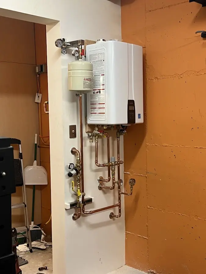 Plumbing technician inspecting water heater connections in Dixon